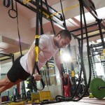 Crossfit fitness TRX push ups man workout at gym